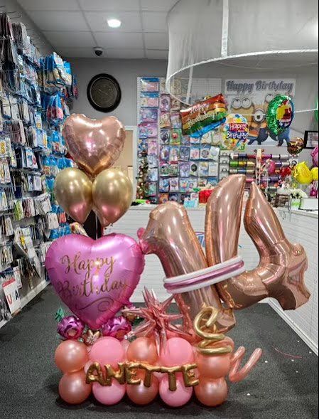 A bunch of balloons are sitting on the floor in a store.