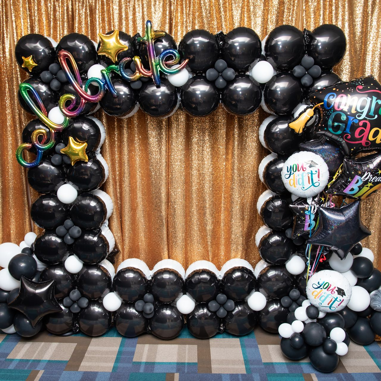 Graduation balloon photo frame with black balloons and gold backdrop for party photos in Fort Worth