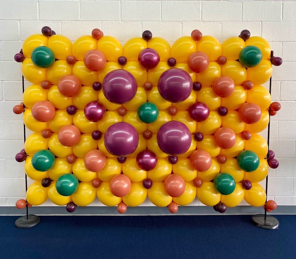 A wall made of yellow and purple balloons