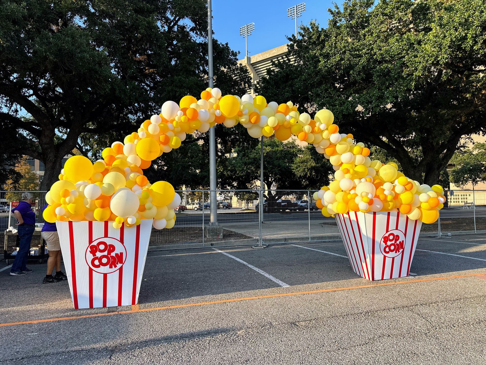 Popcorn theme balloon arch shades of yellow balloons with popcorn boxes on each side 