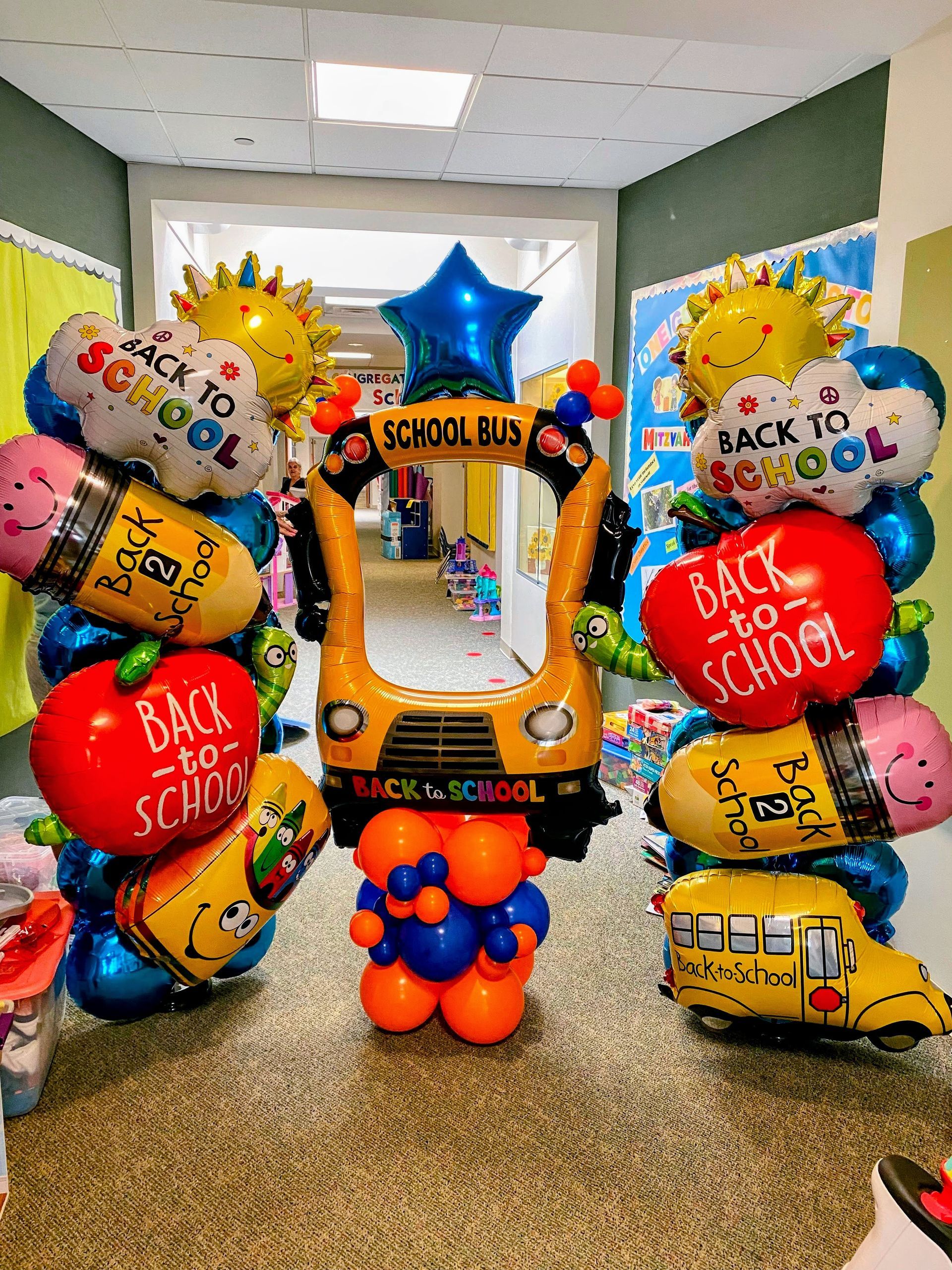 Back to school balloon installation featuring school bus balloons and colorful balloon décor for school events
