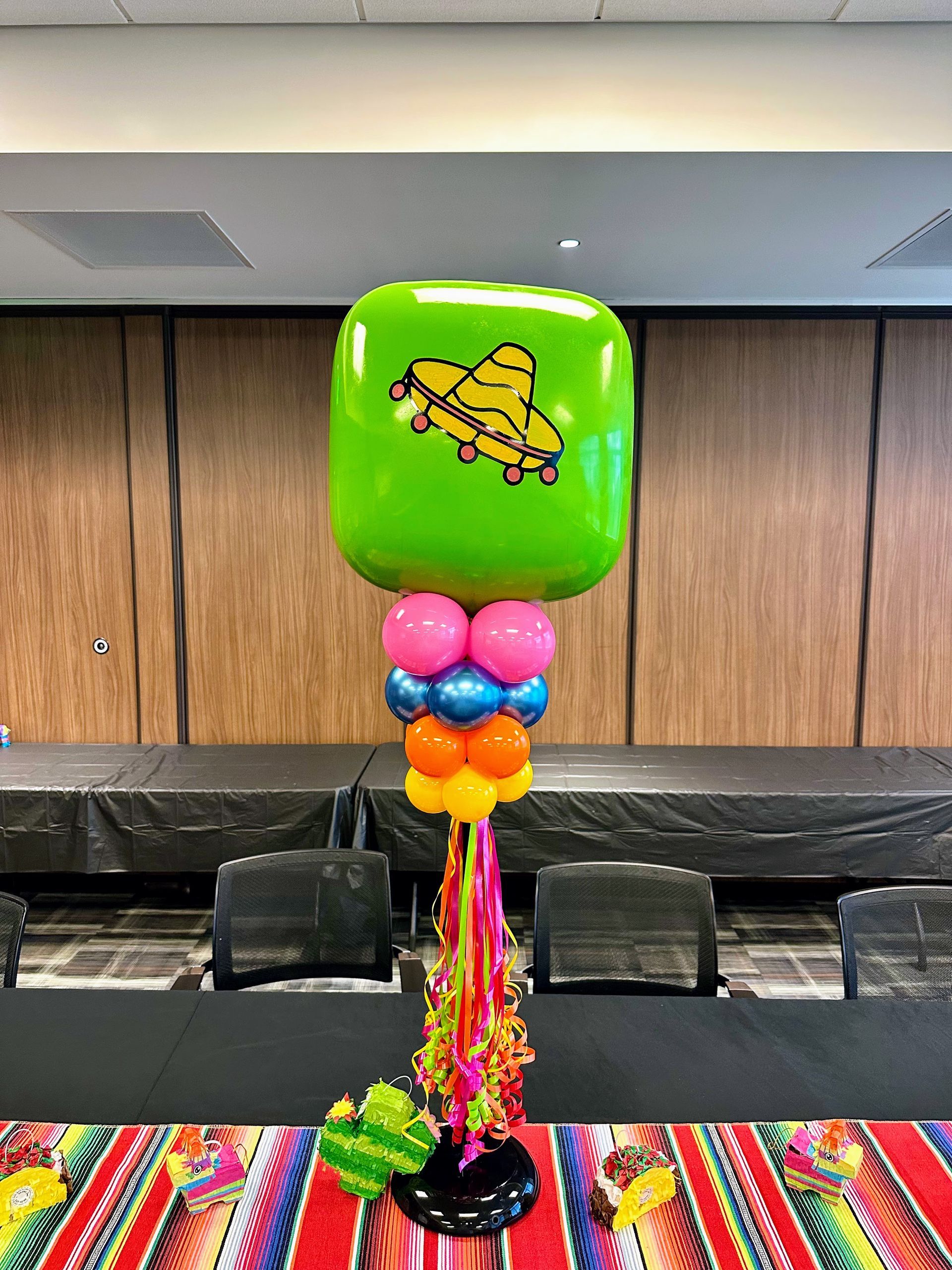 A colorful fiesta themed balloon centerpiece for a party.