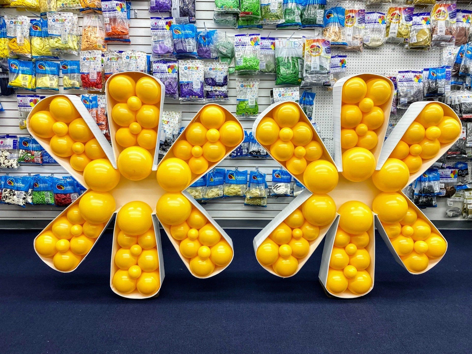 Two letters made out of yellow balloons in a store
