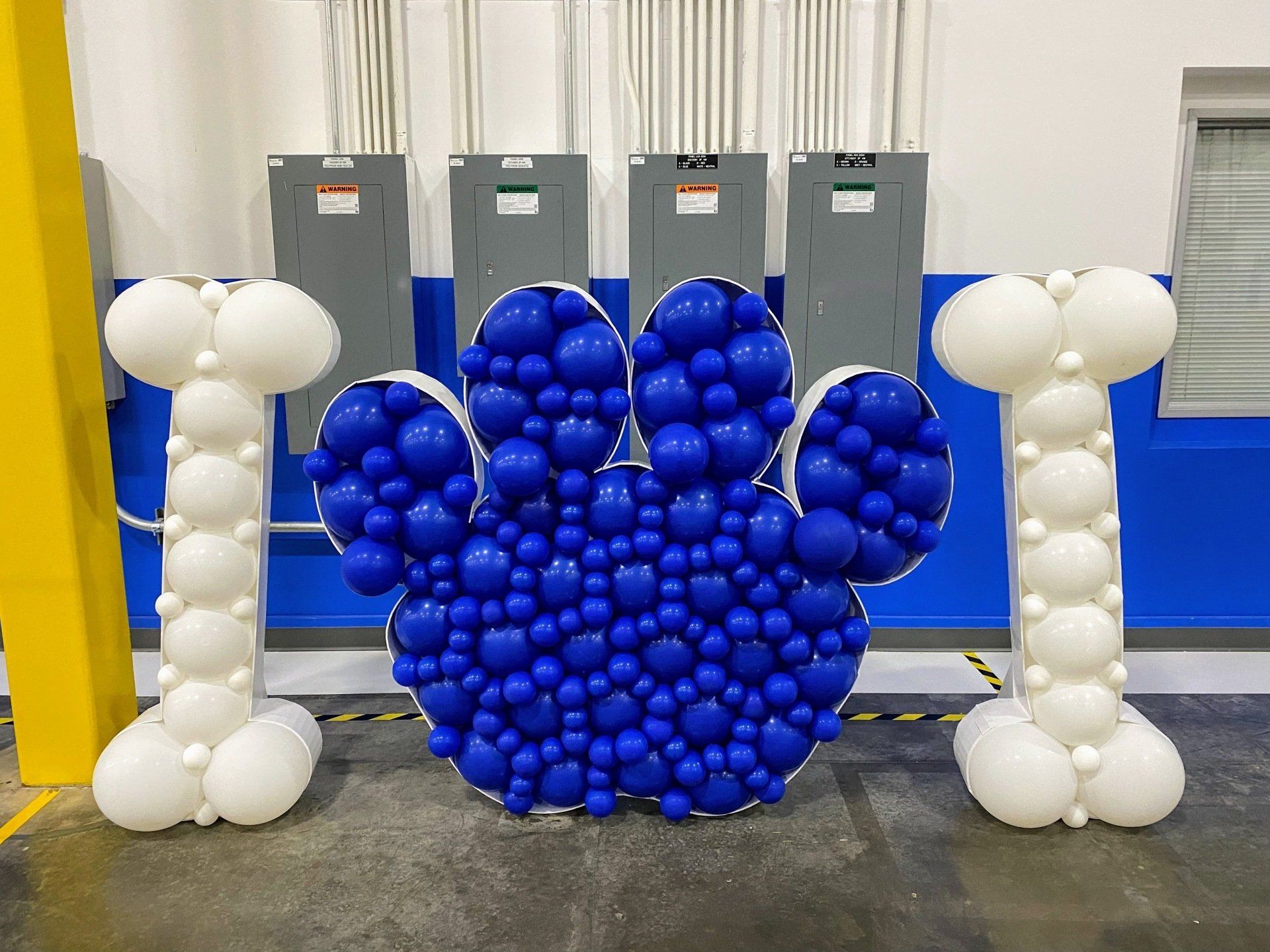 A mickey mouse paw made out of blue and white balloons.