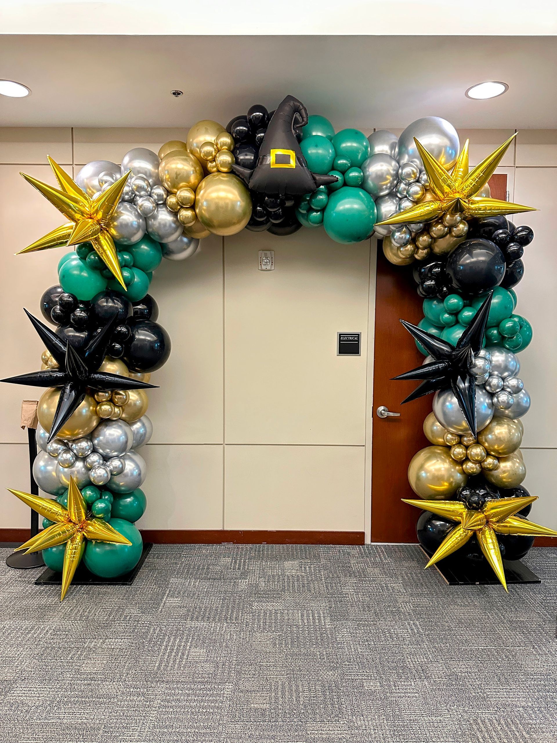 Luxury balloon garland featuring metallic gold, black, and neutral balloons styled for an upscale event
