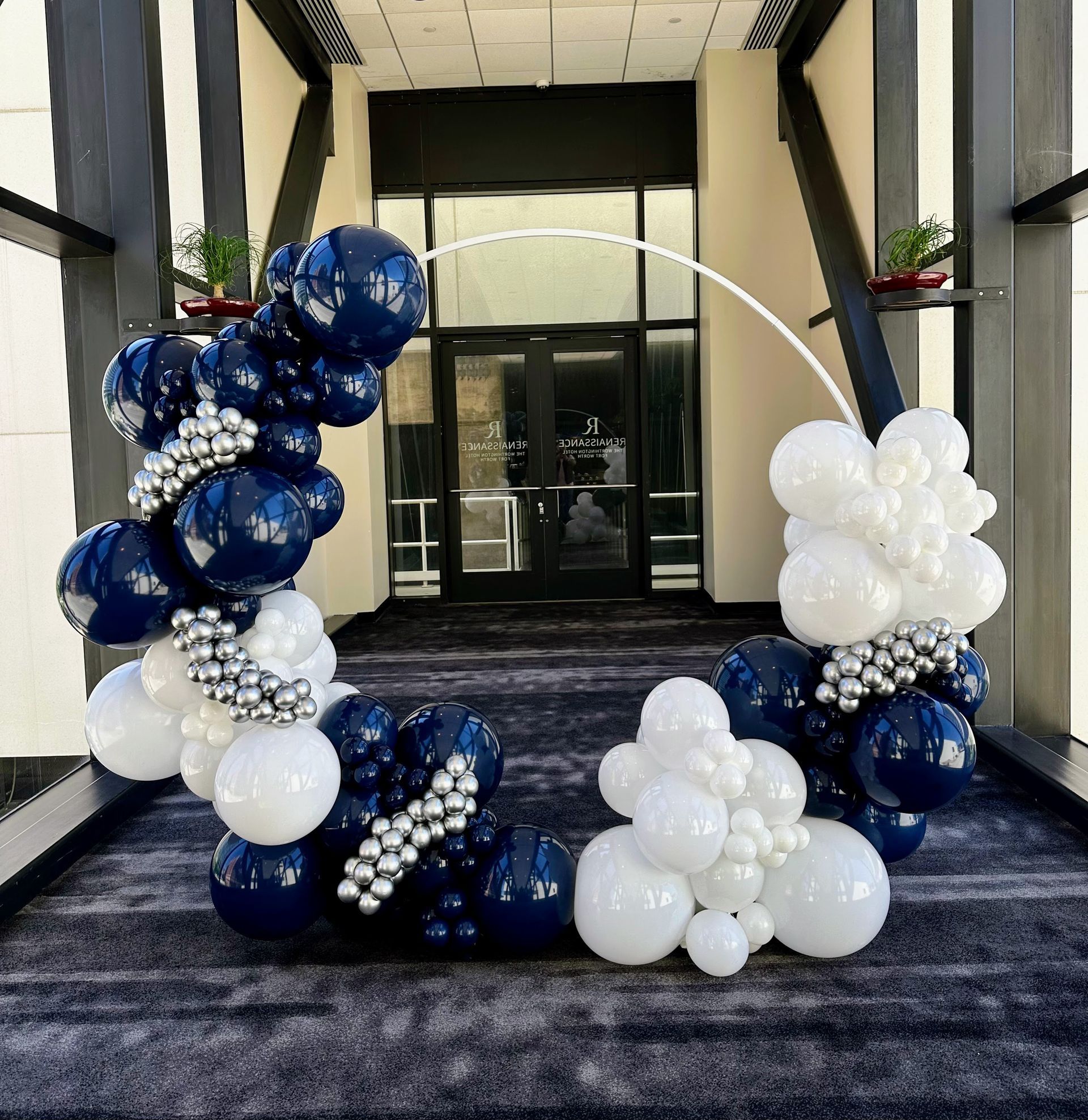 A bunch of blue and white balloons in a hallway