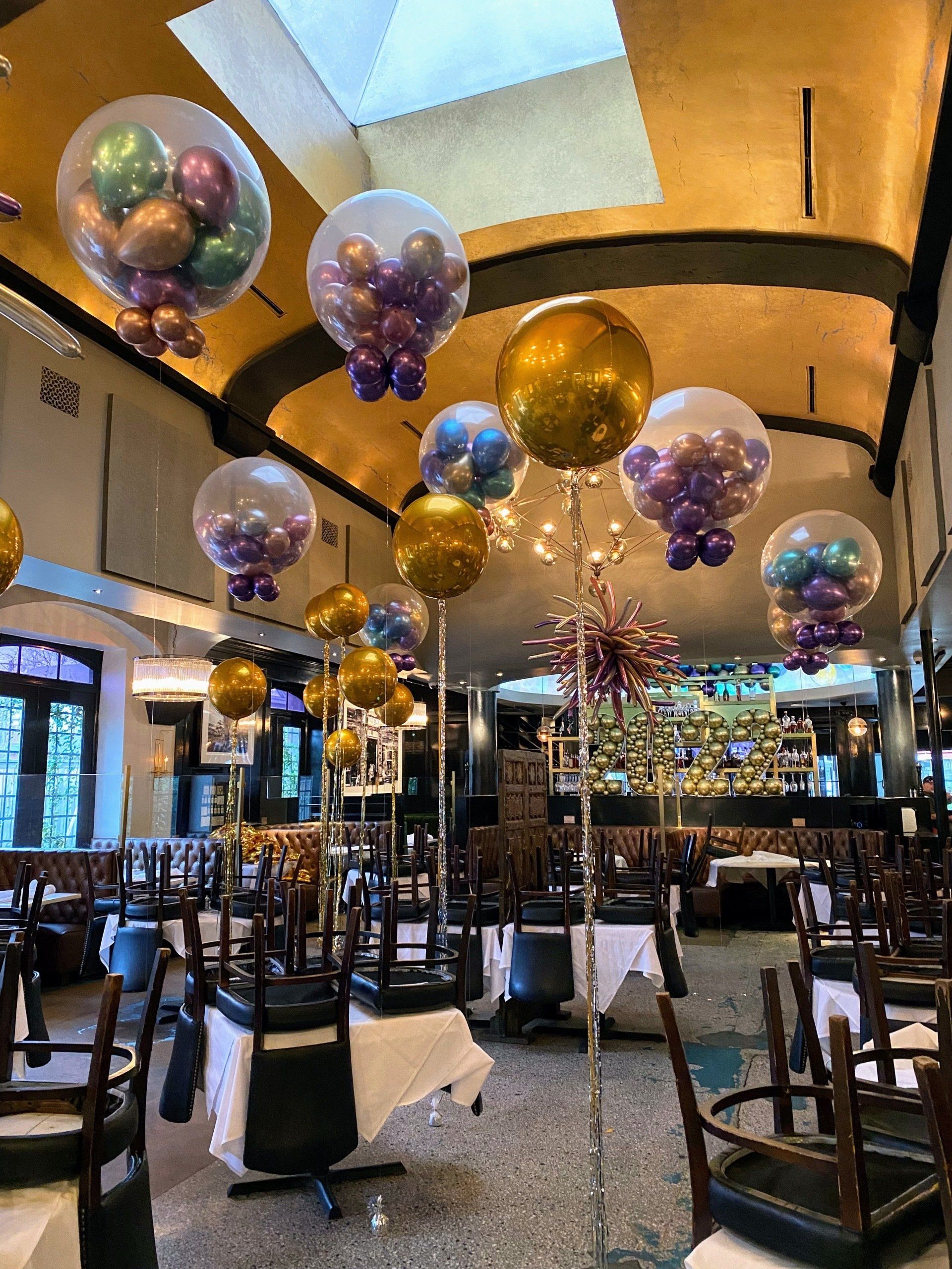 A restaurant filled with tables and chairs and balloons hanging from the ceiling.
