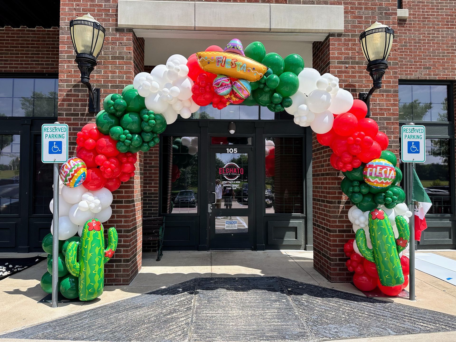 A brick building with a balloon arch in front of it.