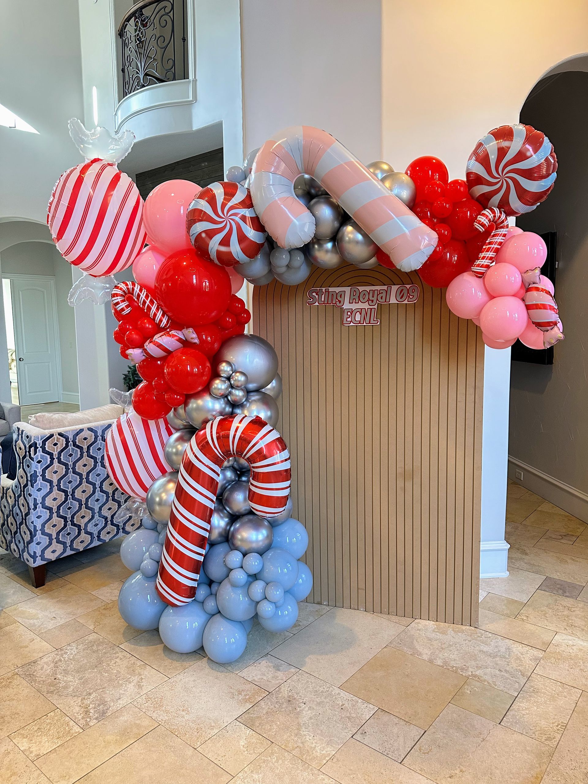 Christmas balloon installation with candy cane accents, red and pink balloons, and festive holiday décor for seasonal events