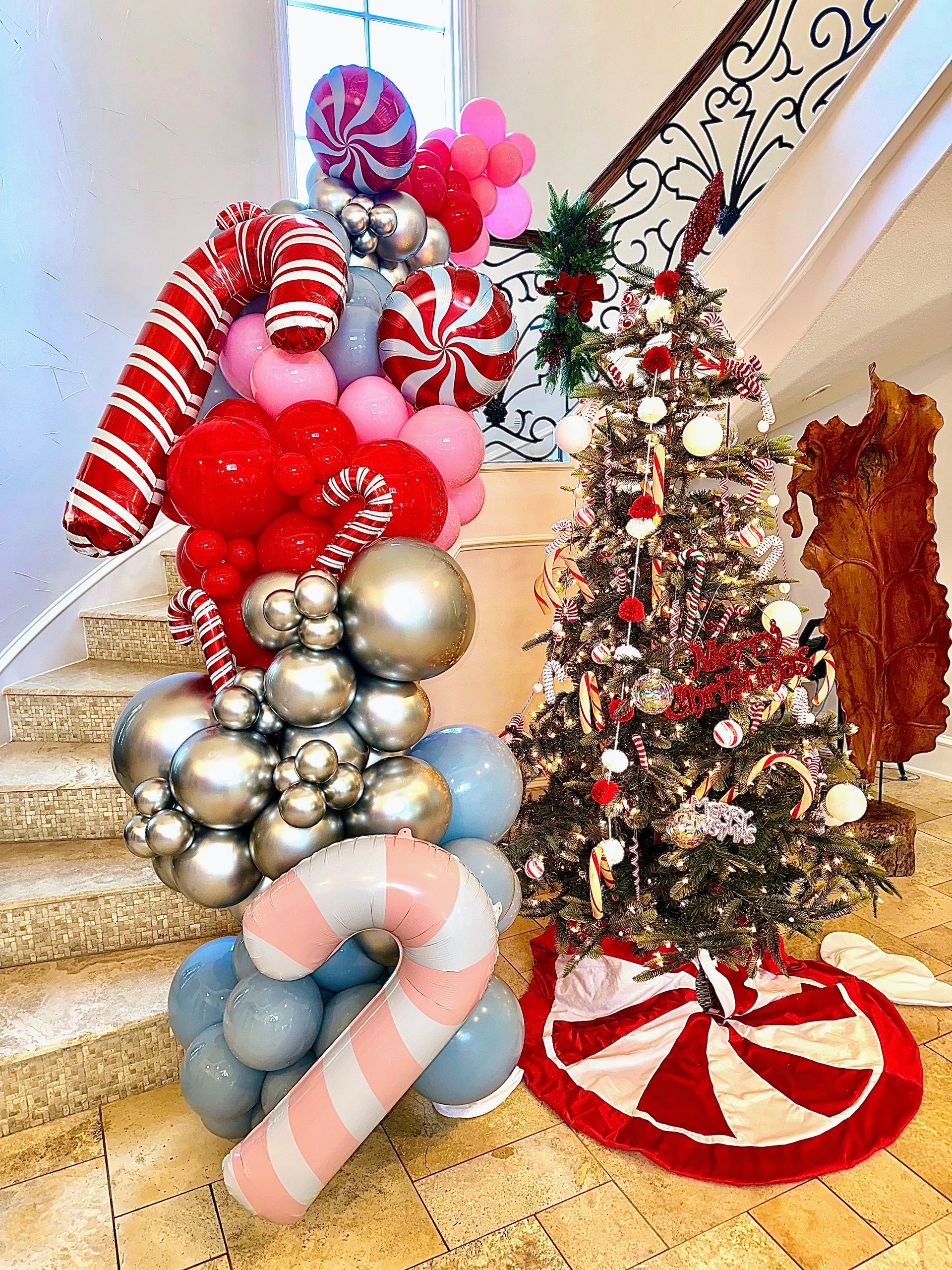 Candy-themed Christmas balloon garland with peppermint accents and festive holiday colors for seasonal events