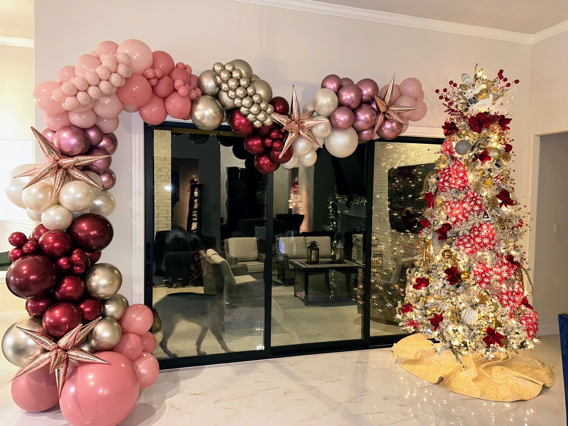 Luxury Christmas balloon arch with metallic and blush balloons paired with holiday décor for upscale seasonal events