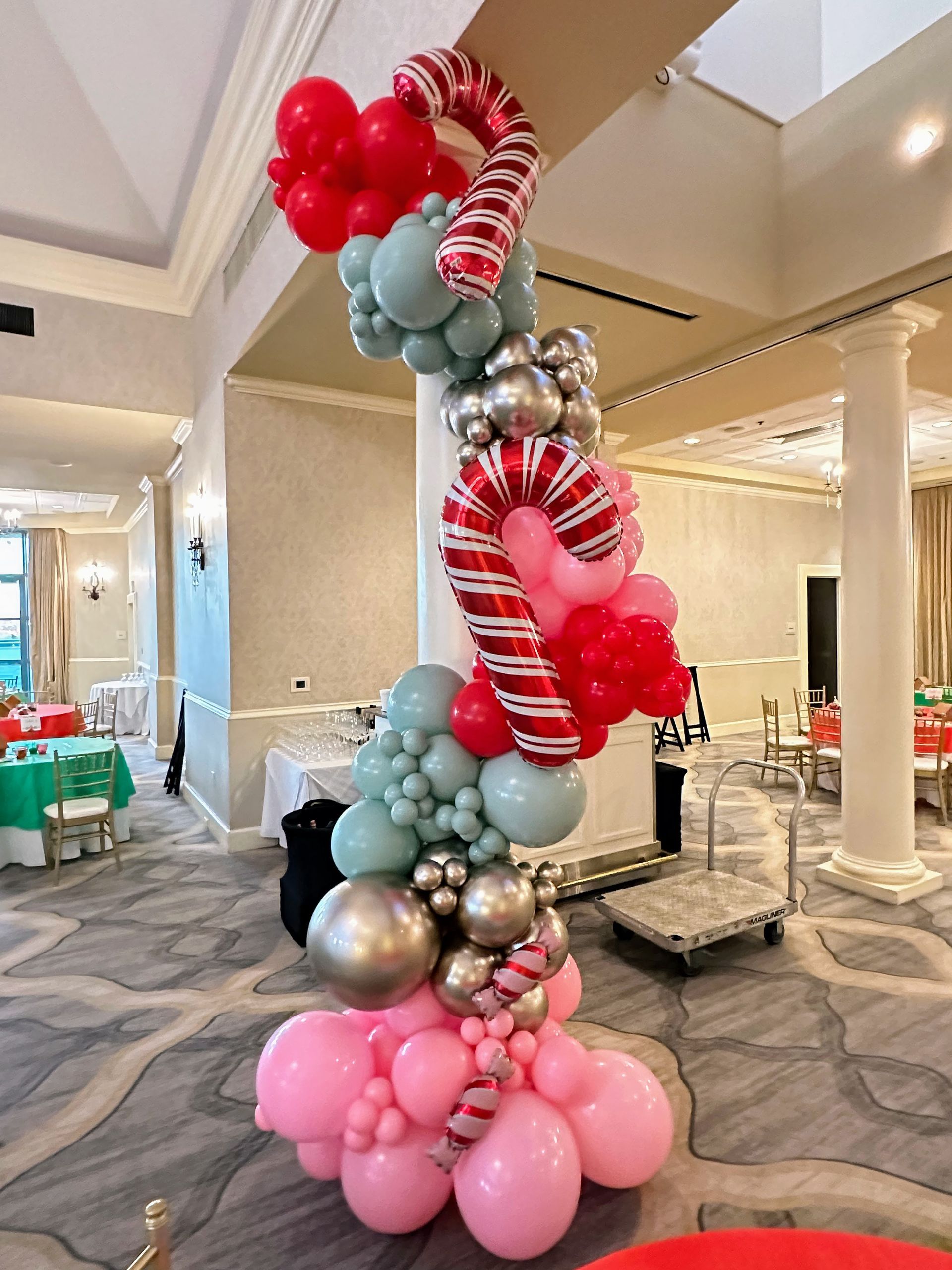 Christmas balloon garland with candy cane details and festive red, white, and metallic balloons for holiday décor