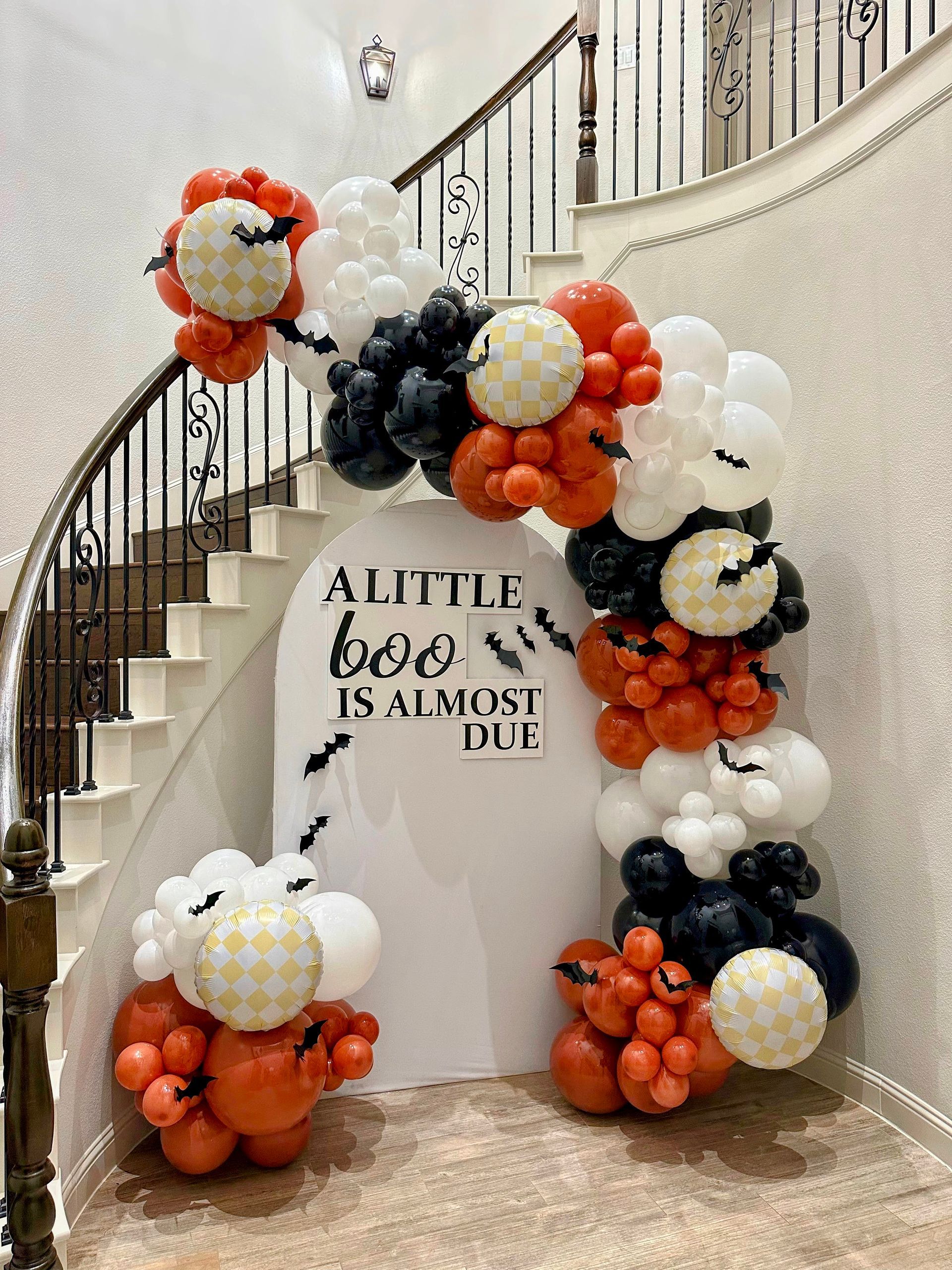 Halloween-themed balloon garland featuring orange, black, and white balloons for festive décor
