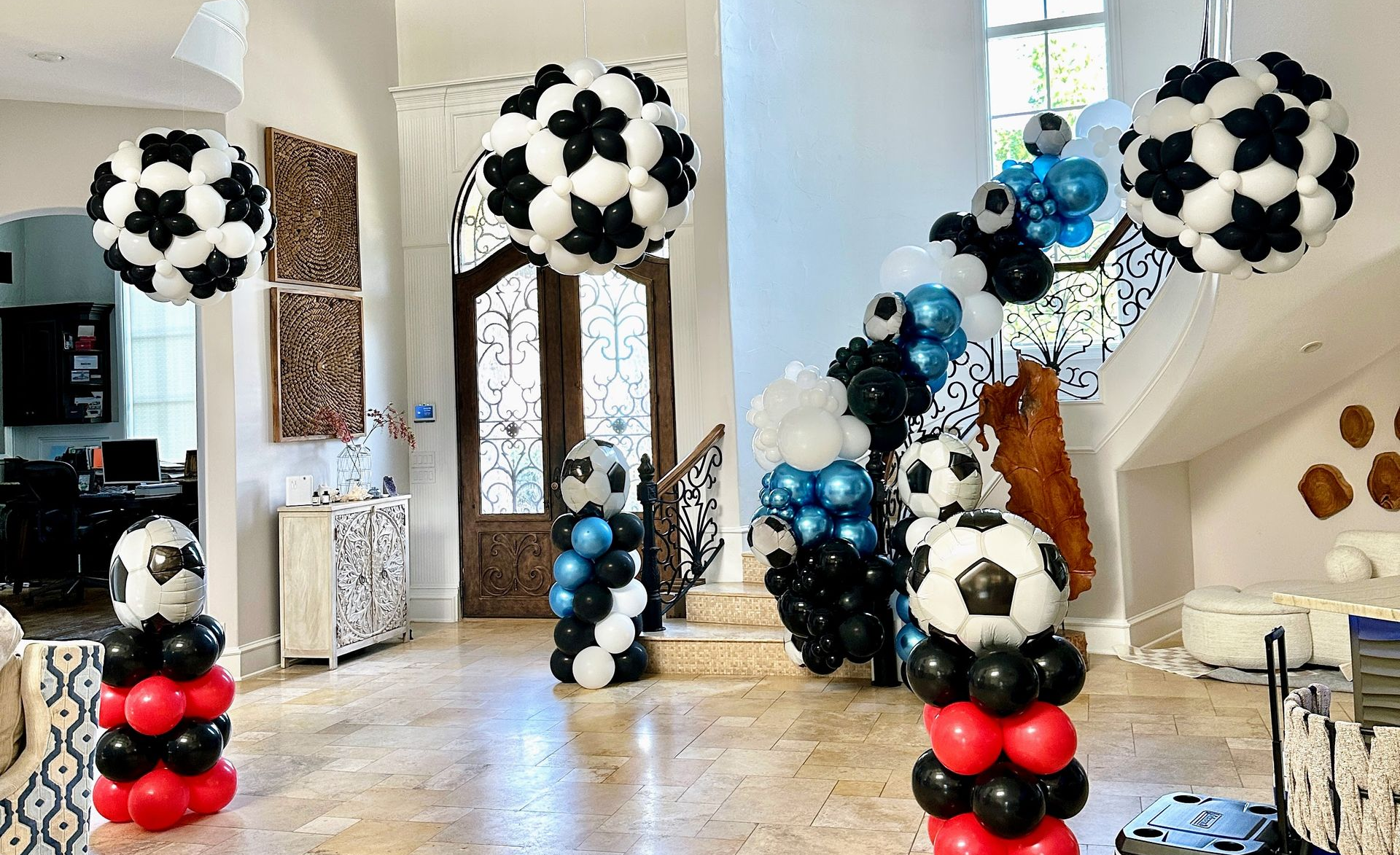 indoor balloon decor with air-filled balloons including a soccer theme organic balloon garland and columns