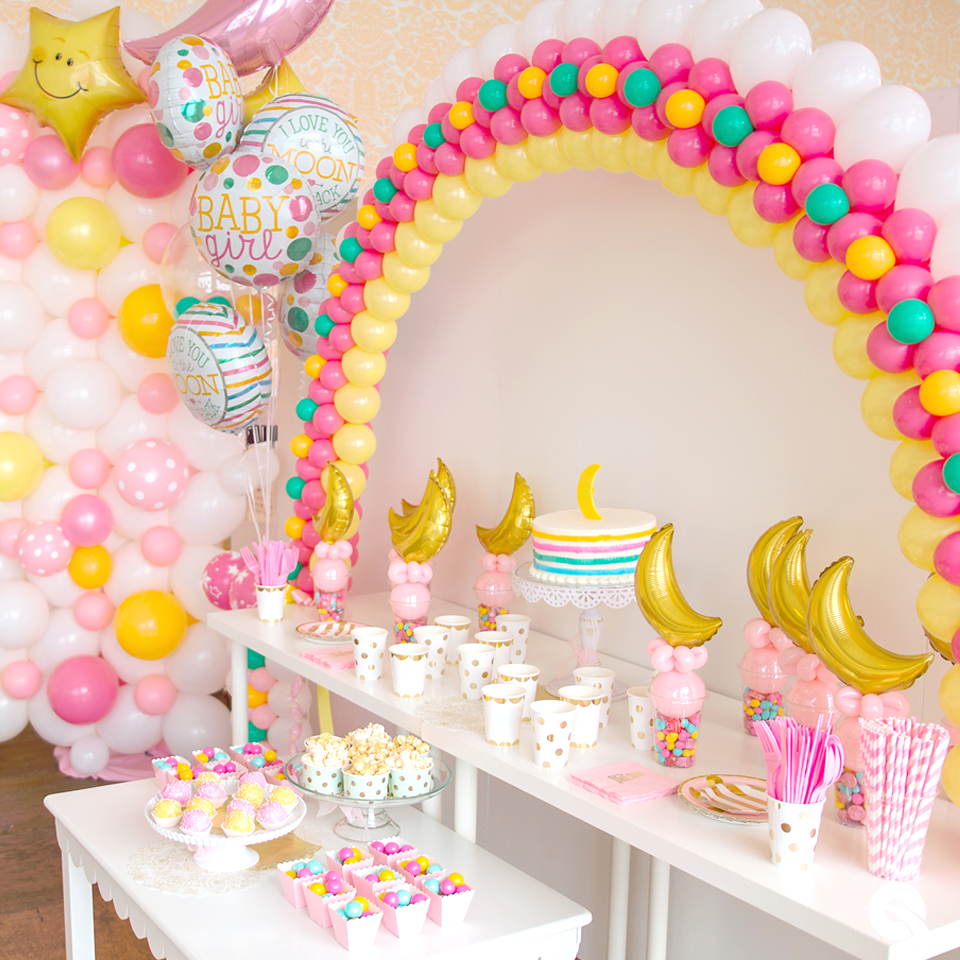 A table decorated with balloons and cupcakes for a baby shower