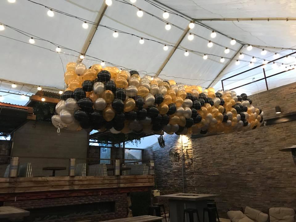 20 foot balloon drop net featuring dark balloons installed above an event floor