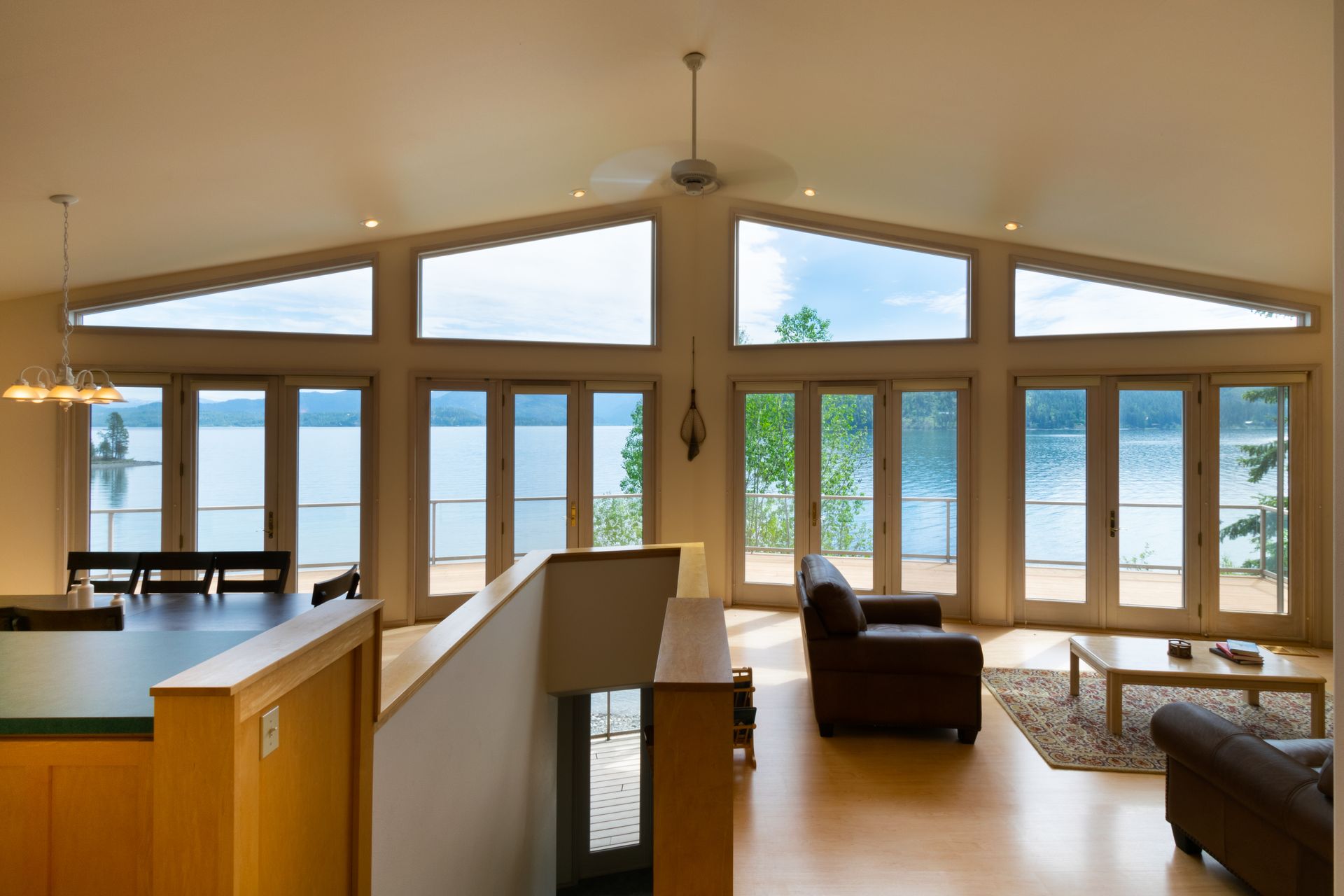 Living room with large windows overlooking a lake. 