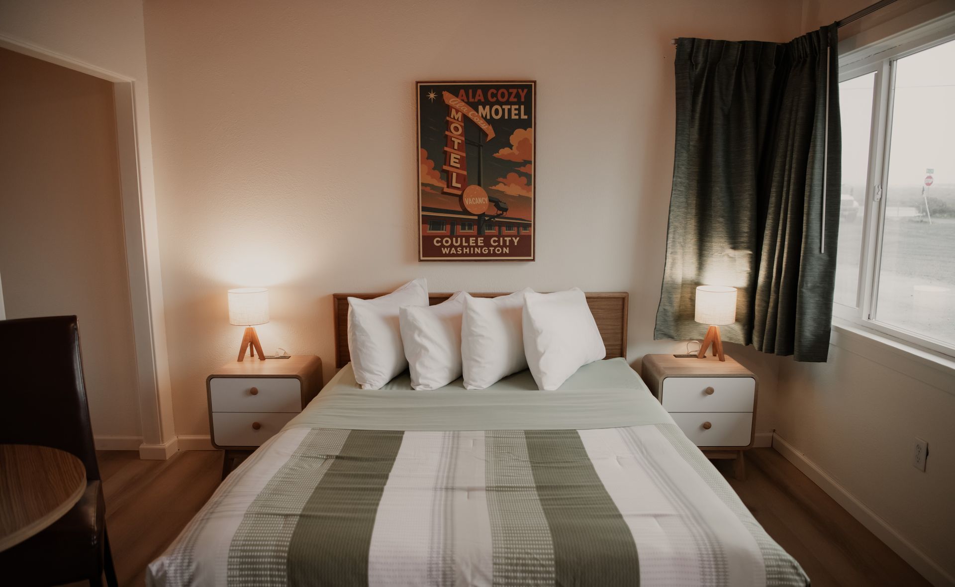 Bedroom with a bed, two nightstands, a window, and artwork on the wall.