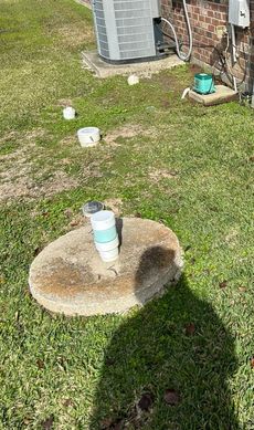 A concrete block is sitting in the middle of a lush green field.