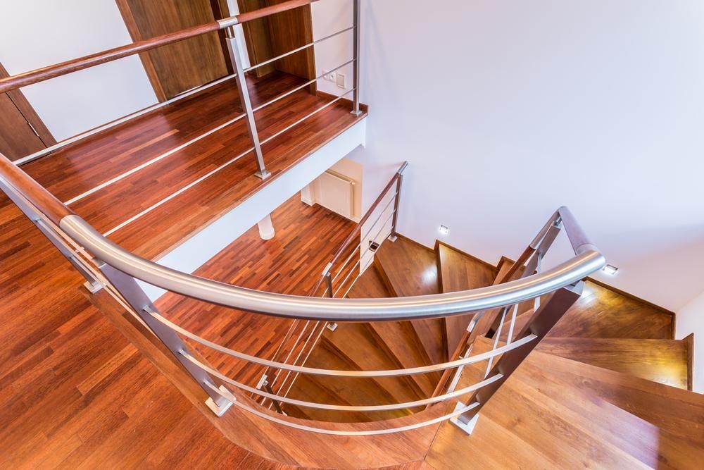 A Wooden Spiral Staircase With a Metal Railing in a House — Kymar Steel Fabrications in Teralba, NSW