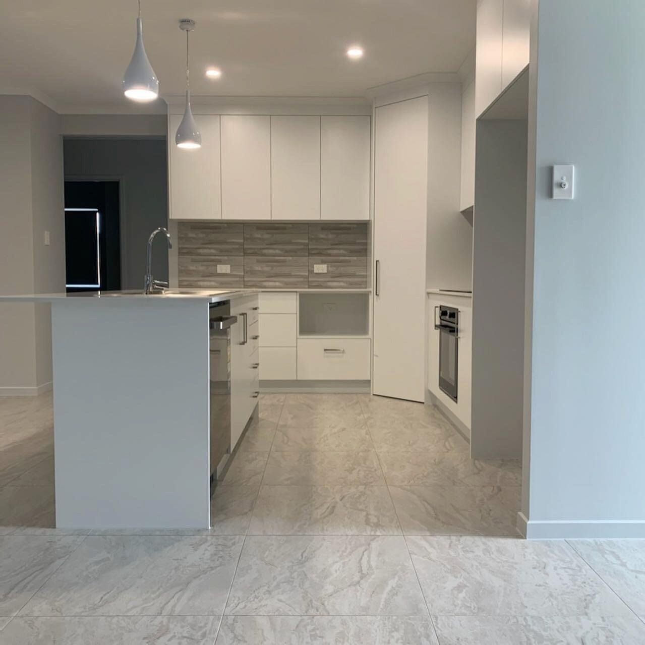A Kitchen With White Cabinets And Stainless Steel Appliances — Cross Cabinets In Chevallum, QLD