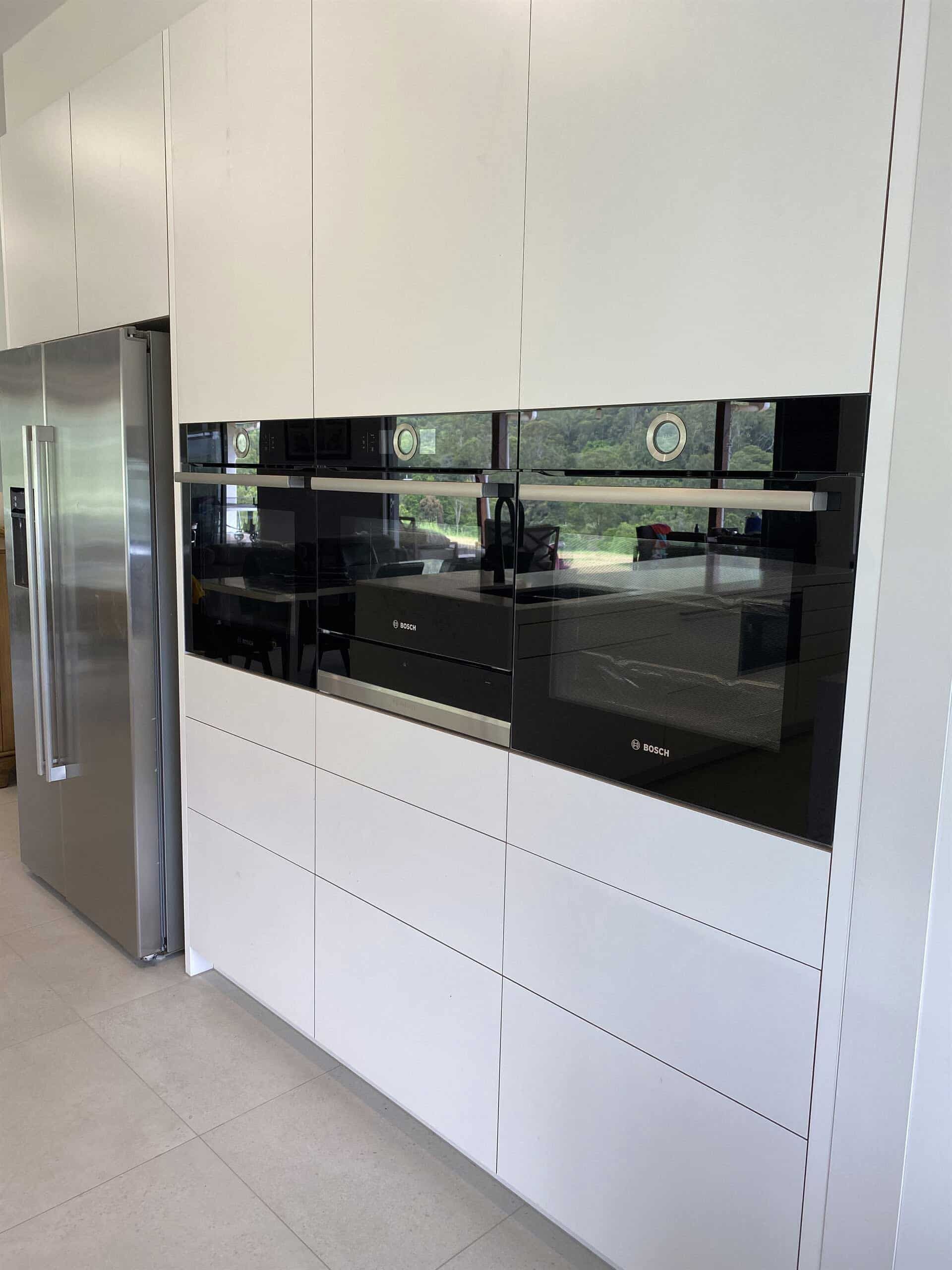 A Kitchen With White Cabinets And Stainless Steel Appliances — Cross Cabinets In Chevallum, QLD