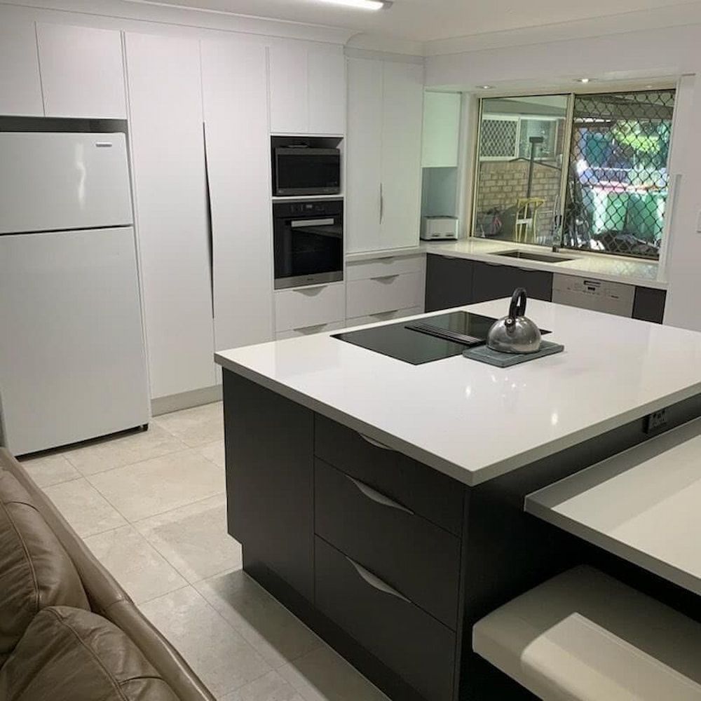 A Kitchen With A Large Island In The Middle Of The Room — Cross Cabinets In Chevallum, QLD
