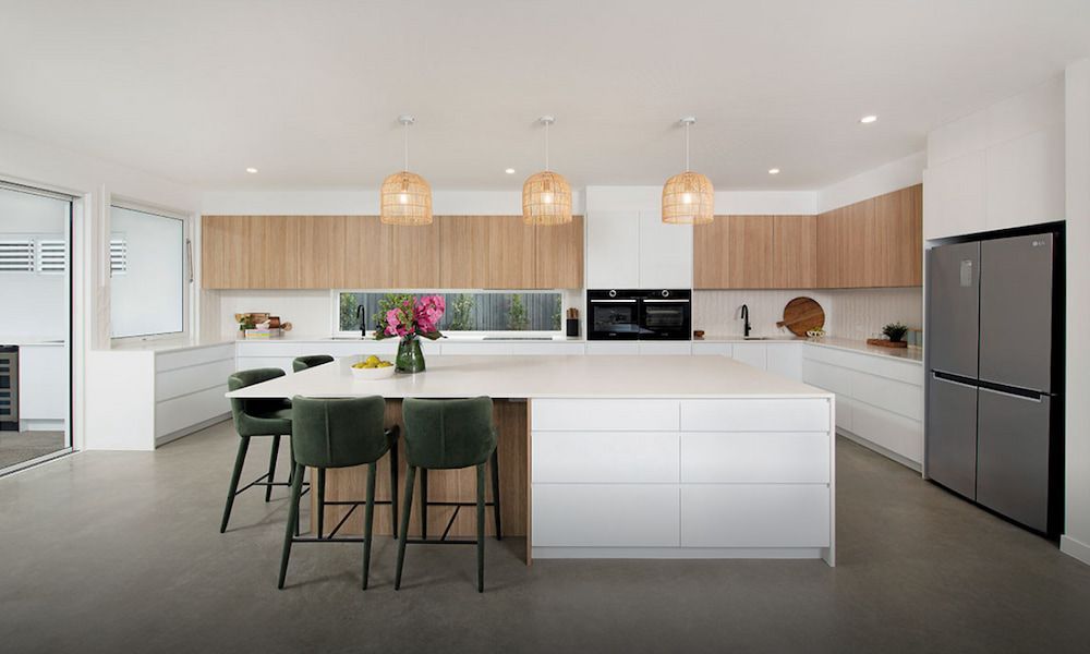 A Kitchen With White Cabinets, A Large Island, Stools And A Refrigerator — Cross Cabinets In Caloundra, QLD