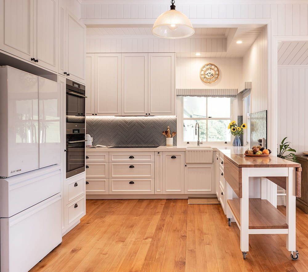 A Kitchen With White Cabinets And Hardwood Floors — Cross Cabinets In Brisbane, QLD