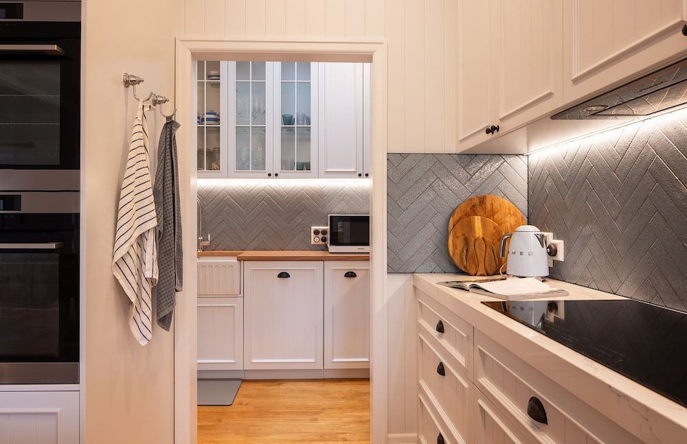A Kitchen With White Cabinets And A Stove Top Oven — Cross Cabinets In Maroochydore, QLD