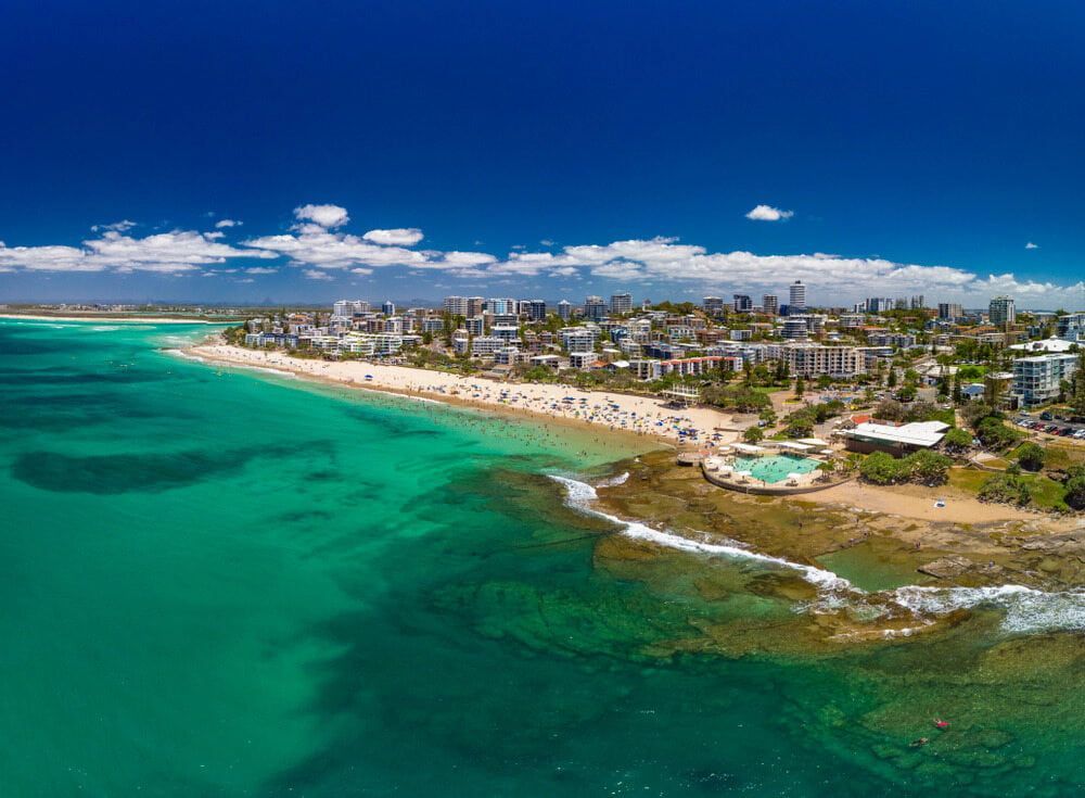 An Aerial View Of A Beach With A City In The Background — Cross Cabinets In Caloundra, QLD