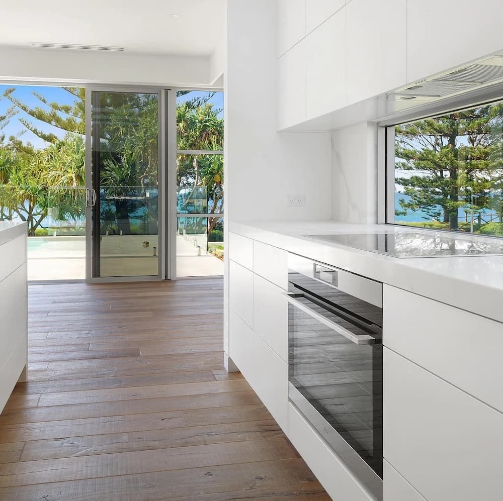 A Kitchen With White Cabinets And Stainless Steel Appliances — Cross Cabinets In Chevallum, QLD