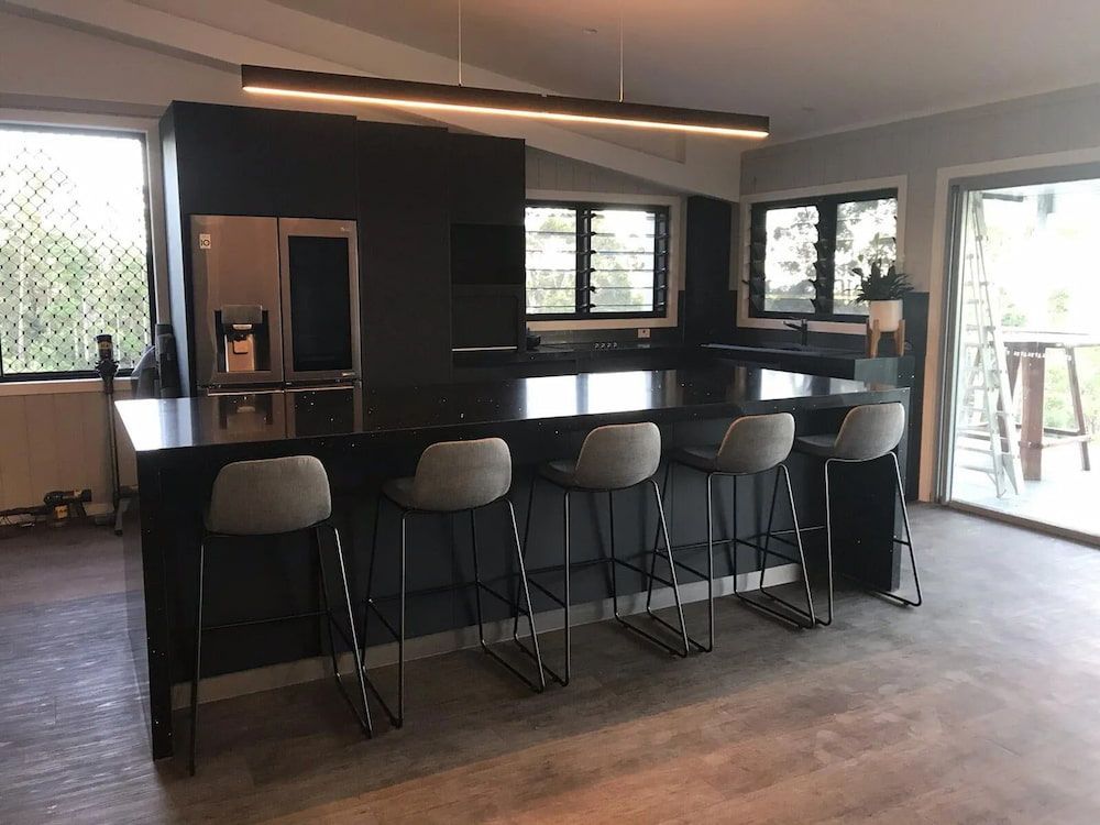 A Kitchen With A Large Island, Stools And A Refrigerator — Cross Cabinets In Noosa, QLD