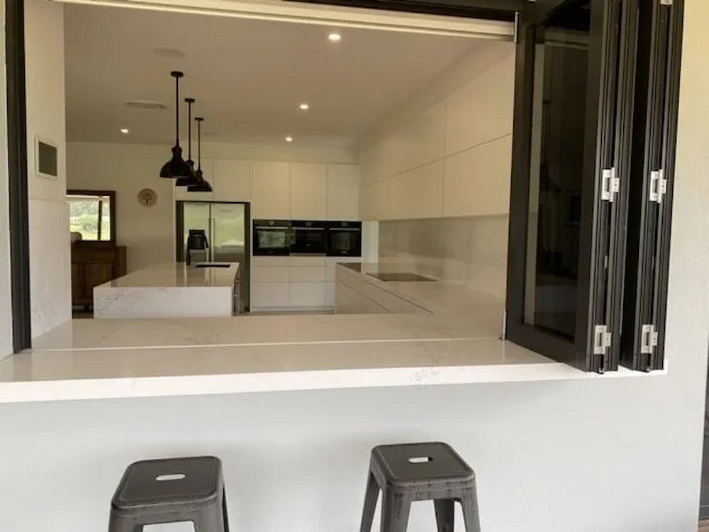 A View Of A Kitchen Through A Window With Two Stools — Cross Cabinets In Brisbane, QLD