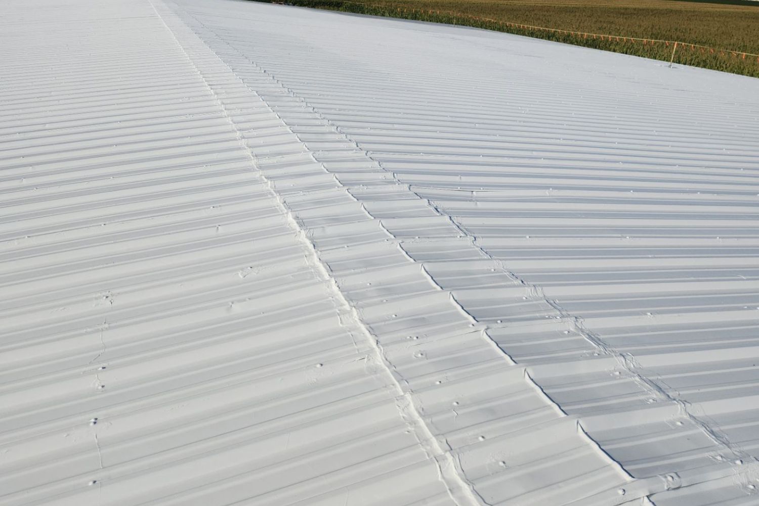 Spray-on roof coating system installed on an existing metal roof