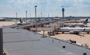 Airport terminal with several airplanes parked at gates under a clear sky