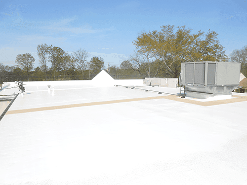Flat white rooftop with HVAC units under a clear blue sky