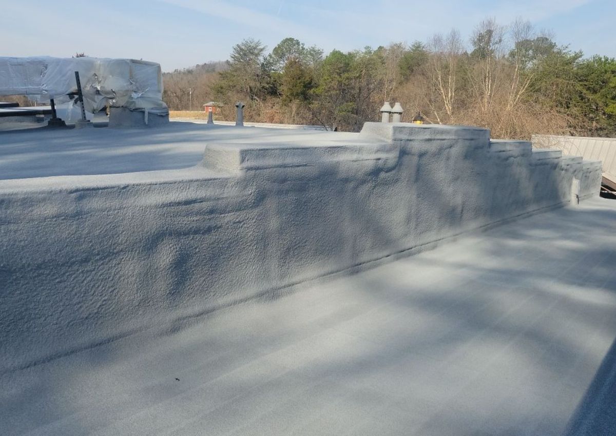 Concrete rooftop with low walls and shadows under a clear sky