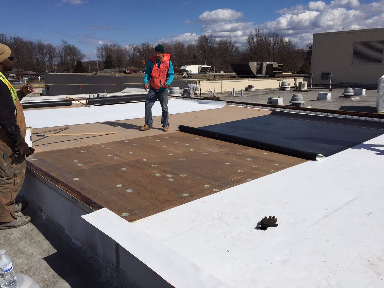 TPO roof being rolled out and installed