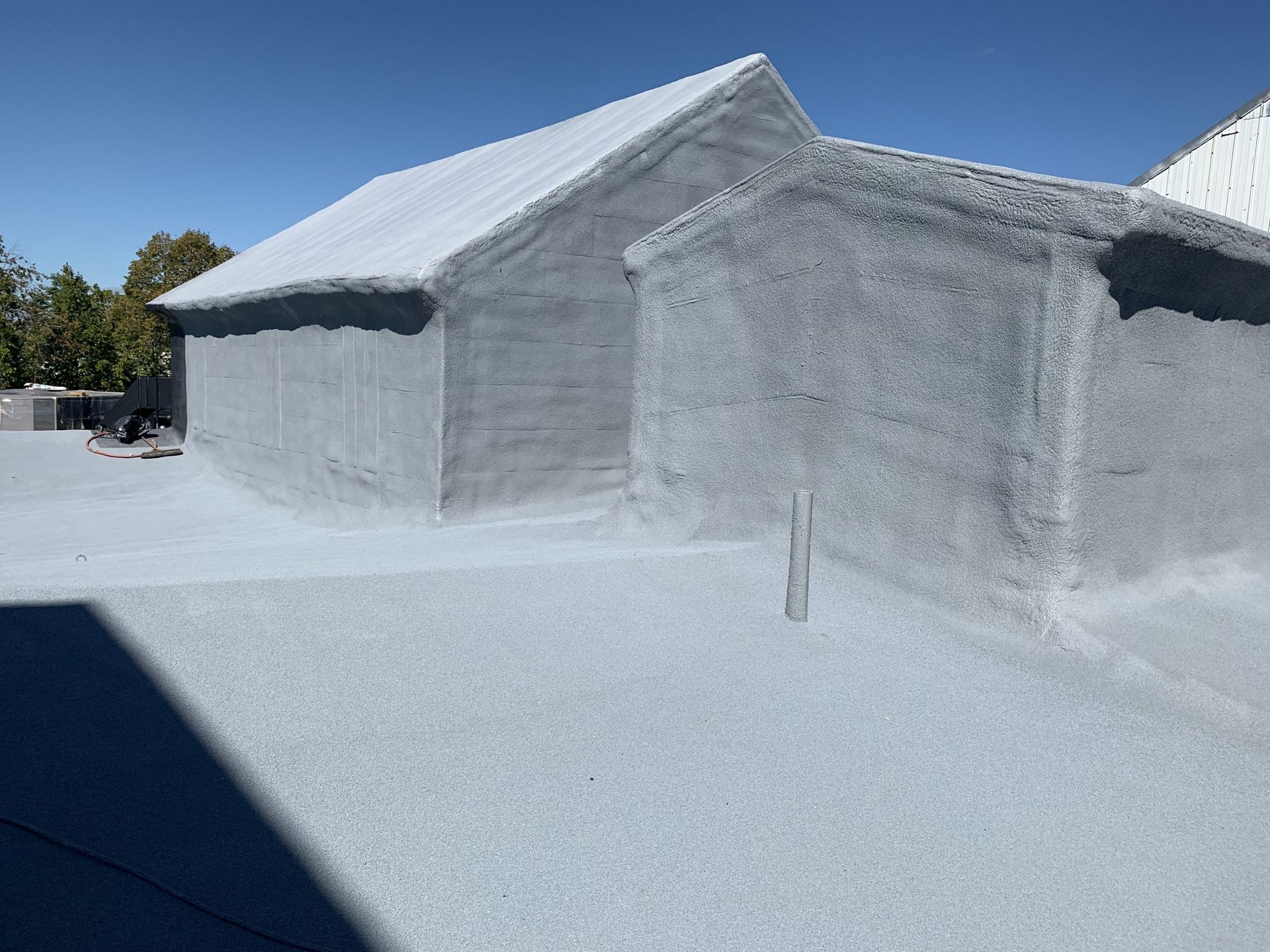 Snow-covered building with sloped roofs and a bright white courtyard under a clear sky