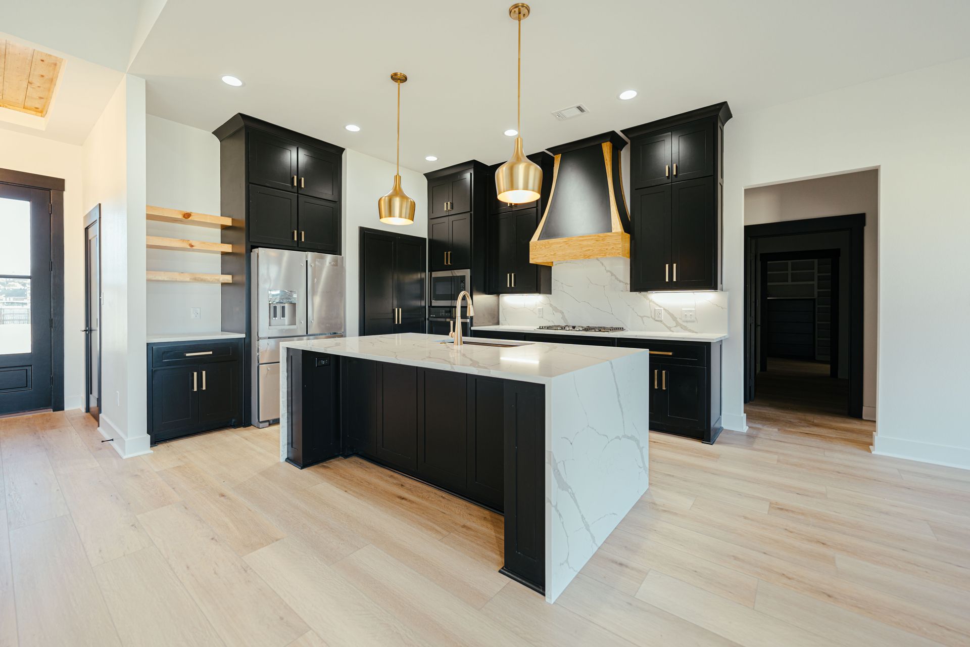 Spacious kitchen with black cabinetry, white countertops, and a large island.