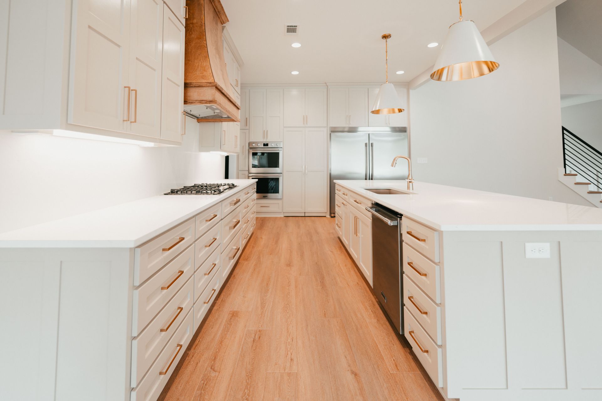 Open kitchen layout with modern white countertops, custom wood details, and pendant lighting.