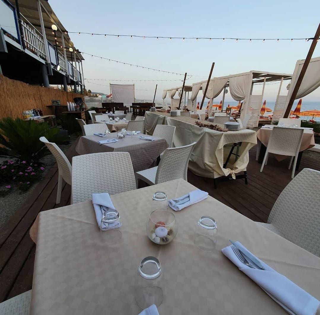 Un ristorante con tavoli e sedie e vista sull'oceano