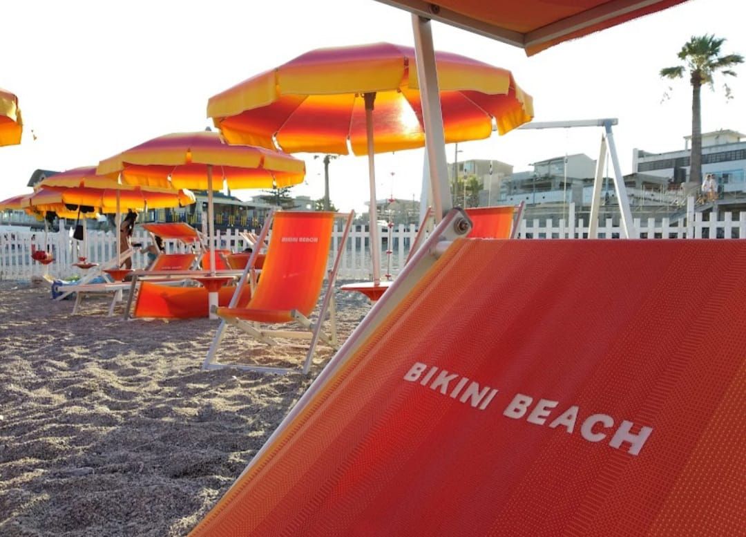 Sedie a sdraio e ombrelloni da spiaggia su una spiaggia sabbiosa