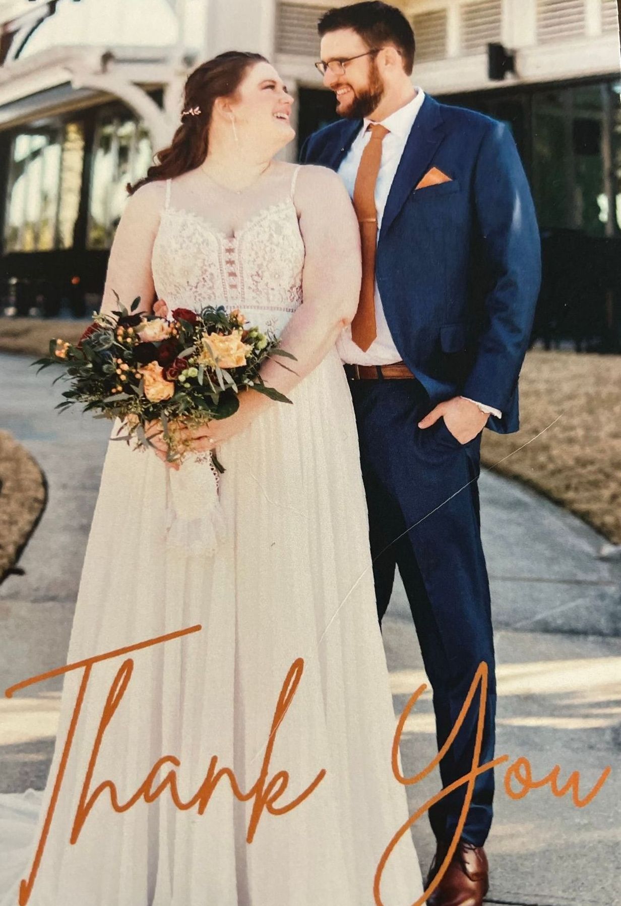 Bride and groom smiling outdoors with bouquet, overlaid with “Thank You” text