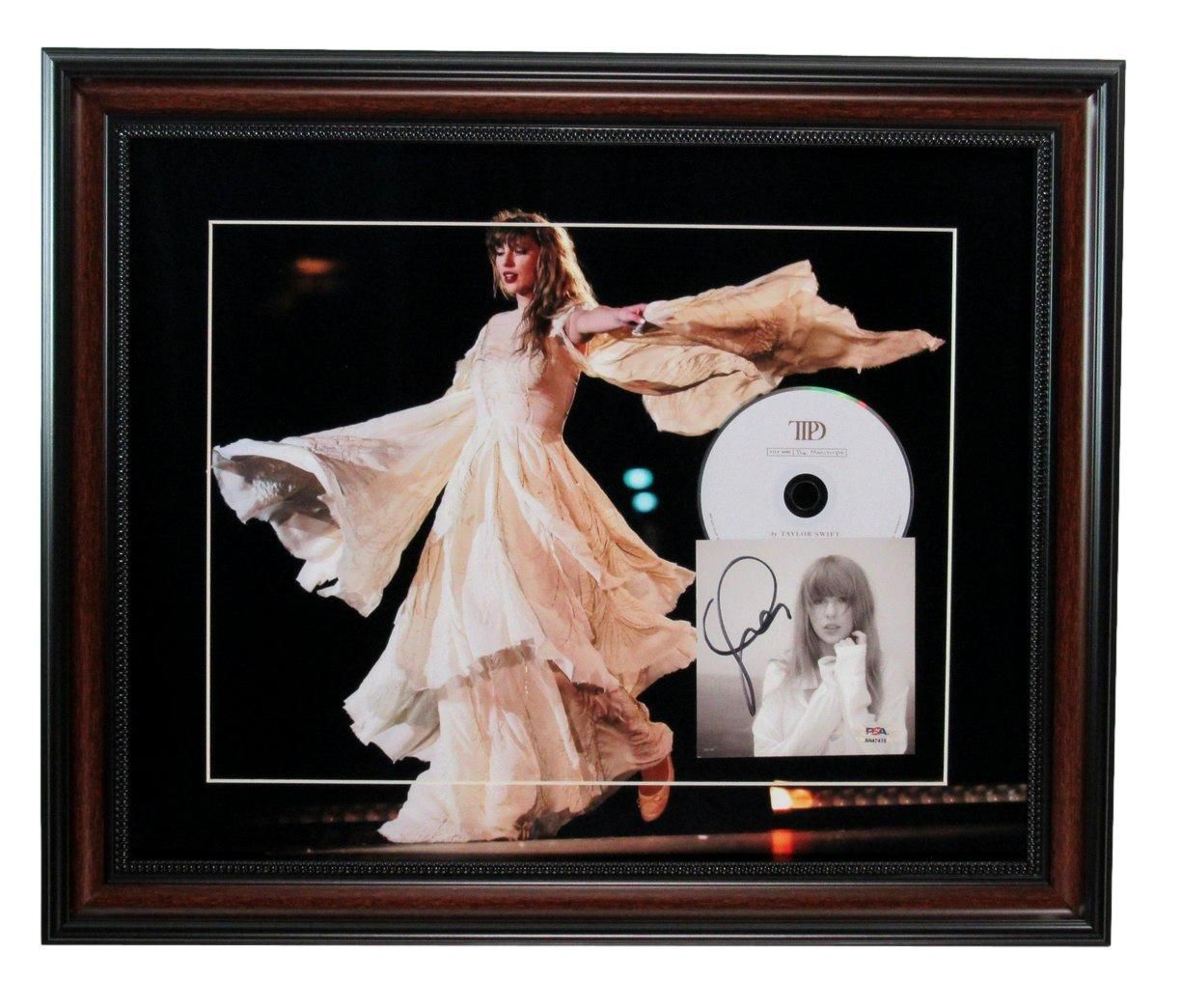 Framed Taylor Swift display: Photo of her performing, CD, signed album cover, all in a dark wood frame.