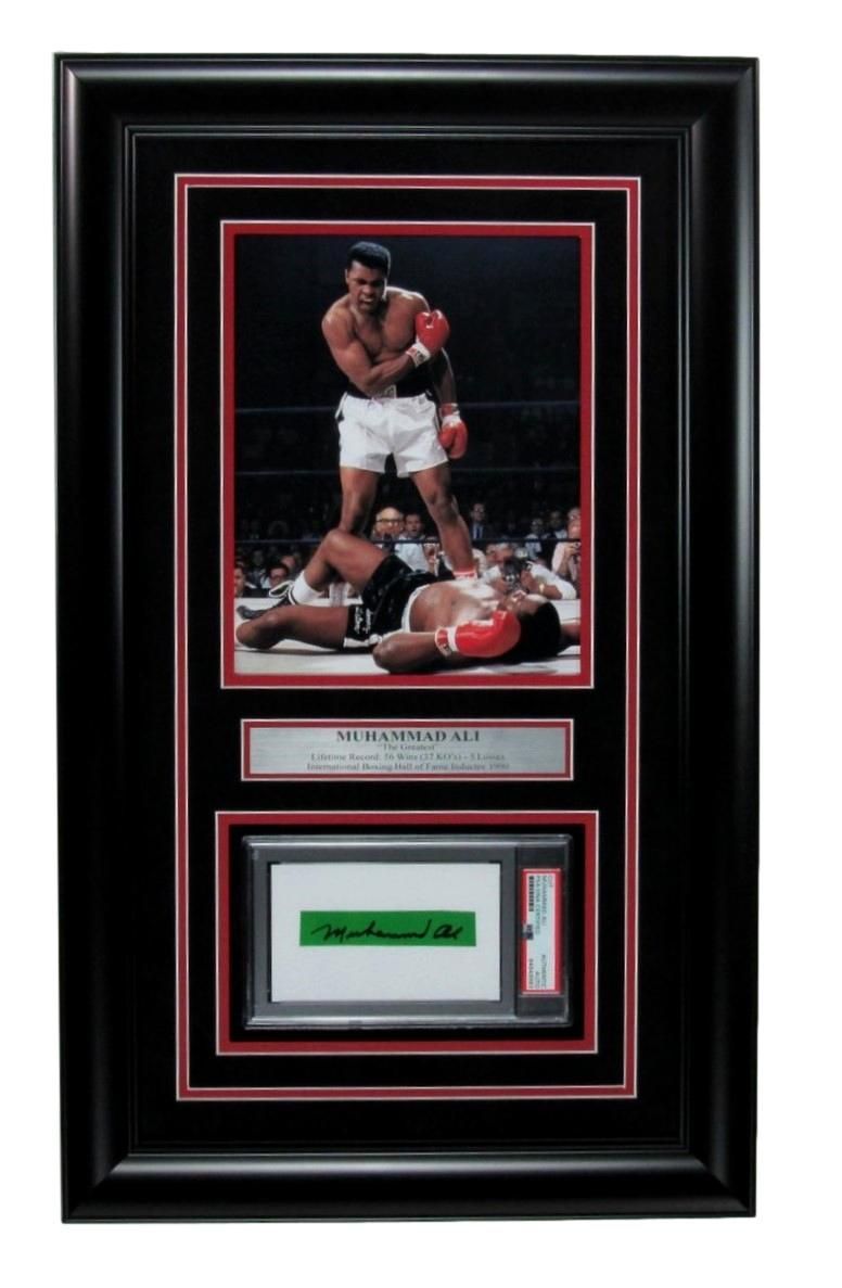 Framed boxing memorabilia: Muhammad Ali over Sonny Liston. Signed autograph below, set in black frame with red accents.