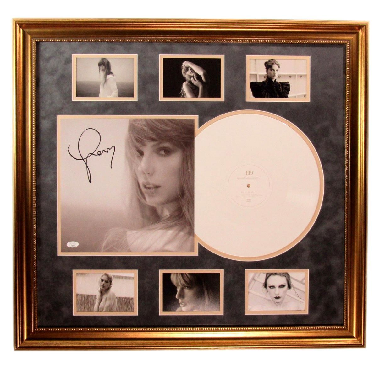 Framed display of a signed album cover and photos, gold frame, white vinyl record.