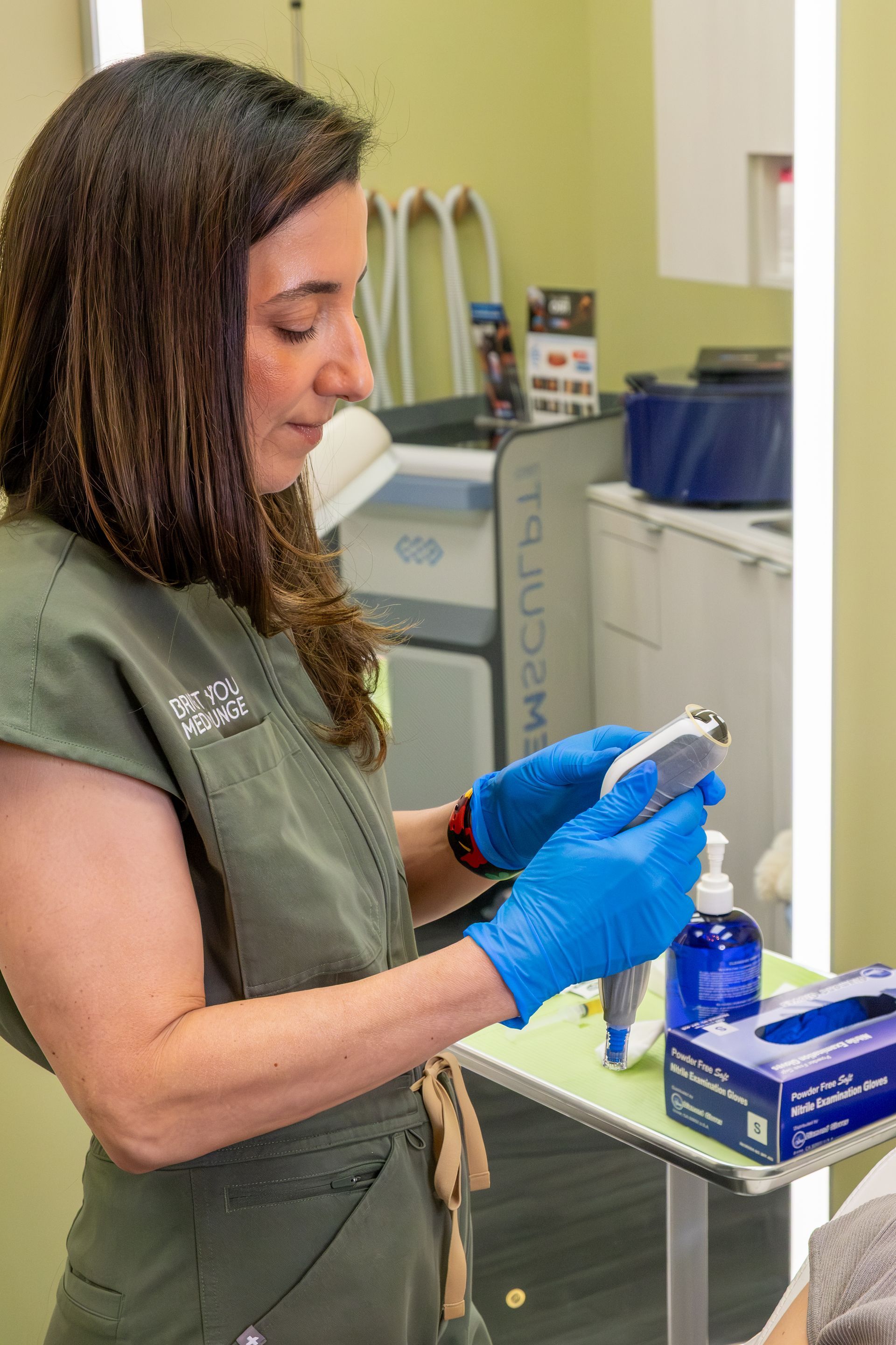 Woman in blue gloves examining a medical sample in a clinical lab