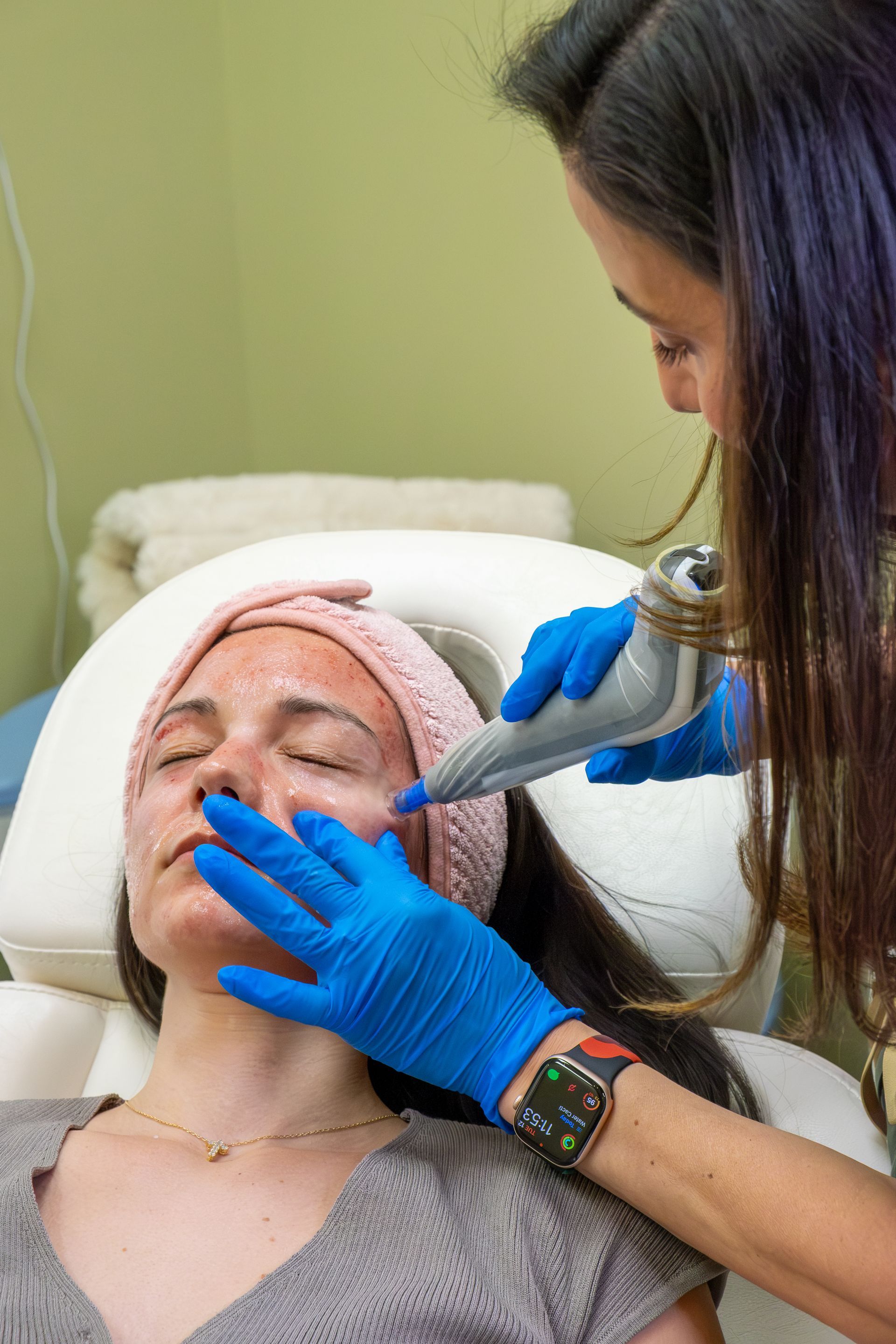 Cosmetician applying facial treatment to a client in a spa setting
